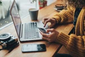 image of Woman in cafe shopping online with laptop